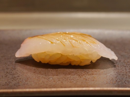 A photo of Banded jacopever (Tanukimebaru) nigiri sushi